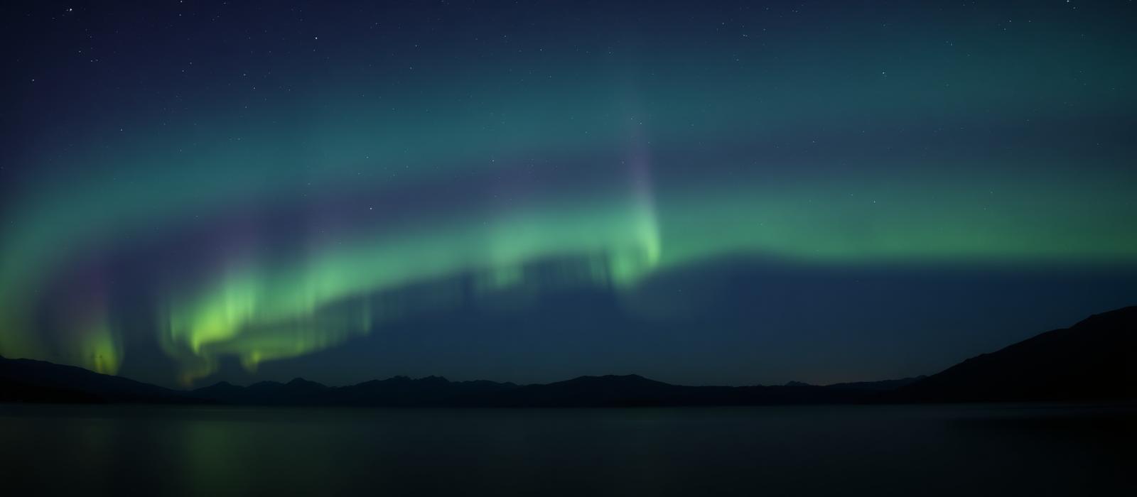 Aurora borealis over a still lake at night
